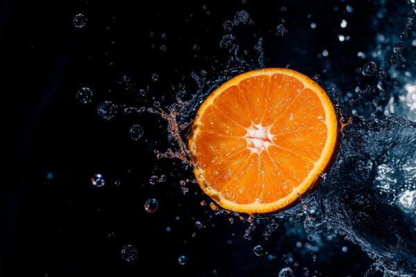 Orange im Spritzwasser auf schwarzem Hintergrund