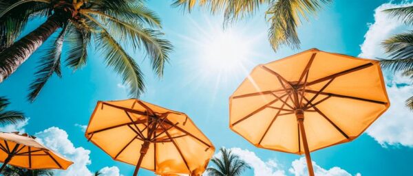 Sonnenschirme unter Palmen am Strand