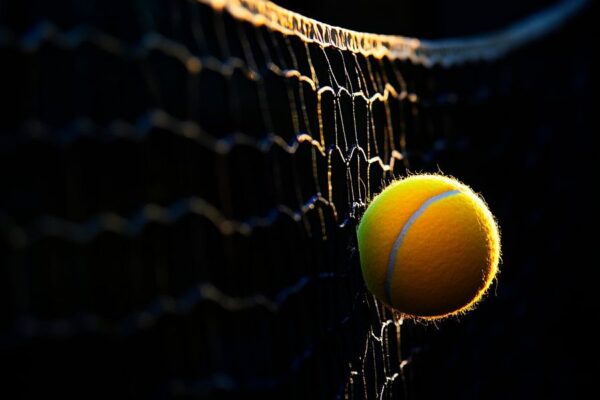 Tennisball hängt im Netz bei Sonnenuntergang